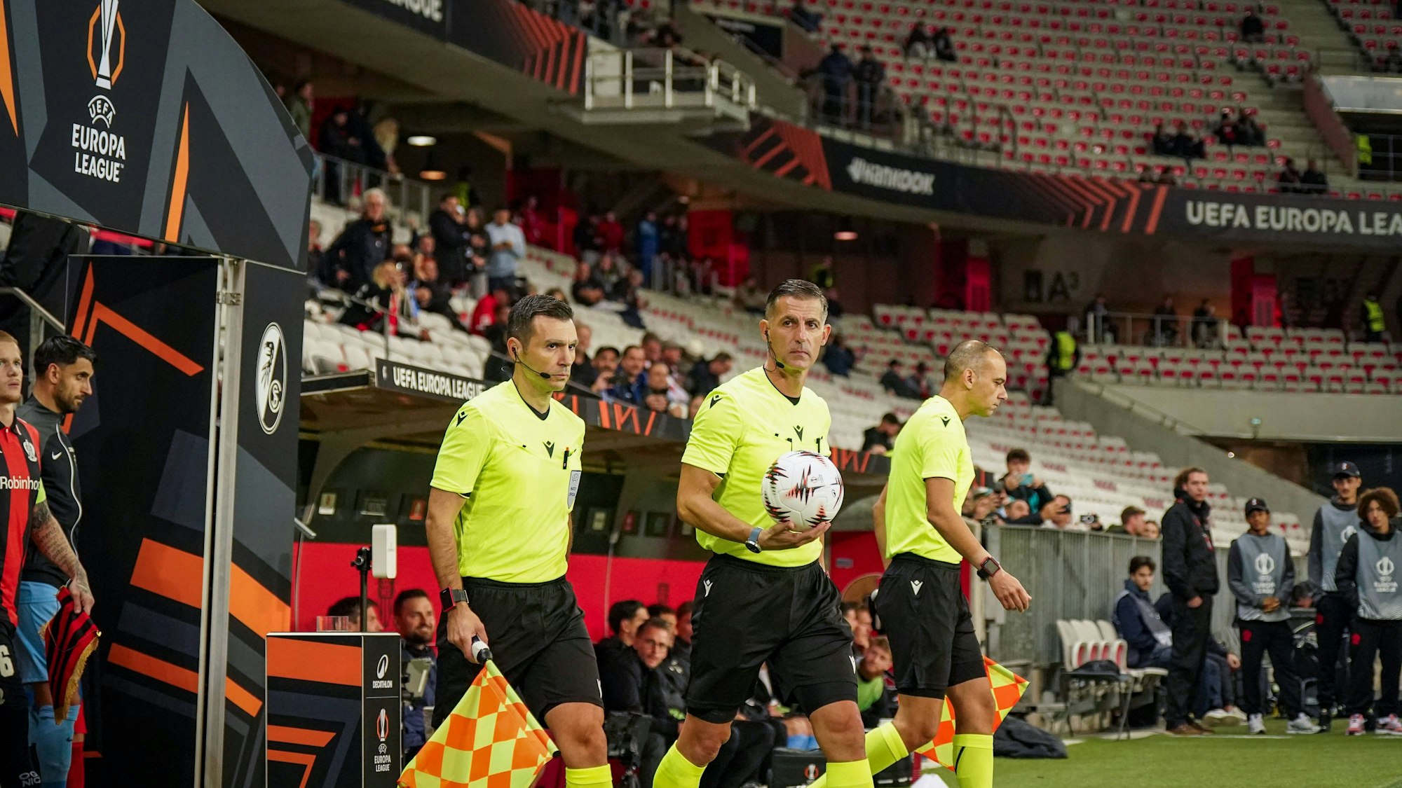 Schiedsrichter Anastasios Sidiropoulos geht mit seinen Assistenten auf den Platz.