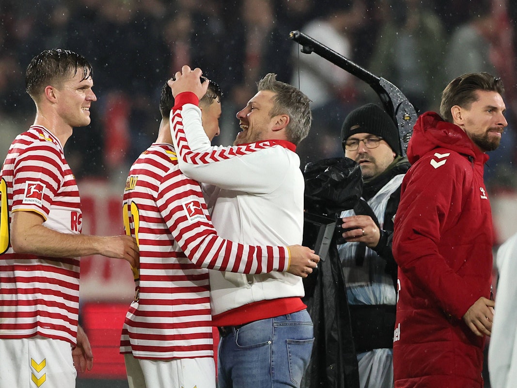 Lukas Kwasniok herzt Said El Mala, daneben steht Marius Bülter und lächelt.