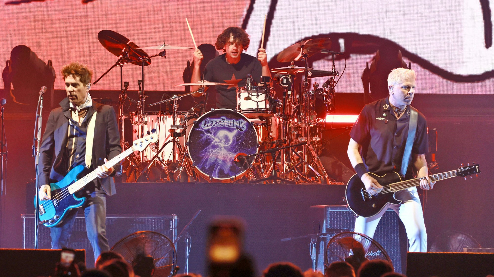 Die Bandmitglieder der Band The Offspring stehen mit ihren Musikinstrumenten auf der Bühne.