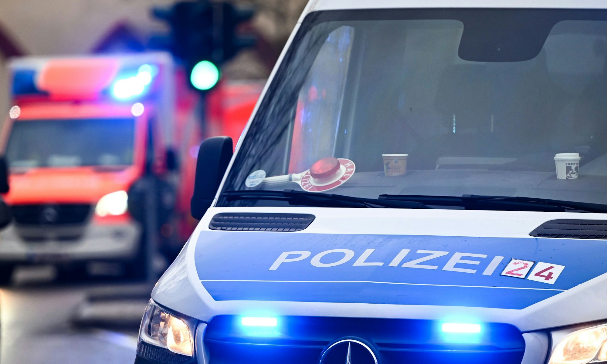 Ein Polizeiauto und ein Rettungswagen mit Blaulicht.