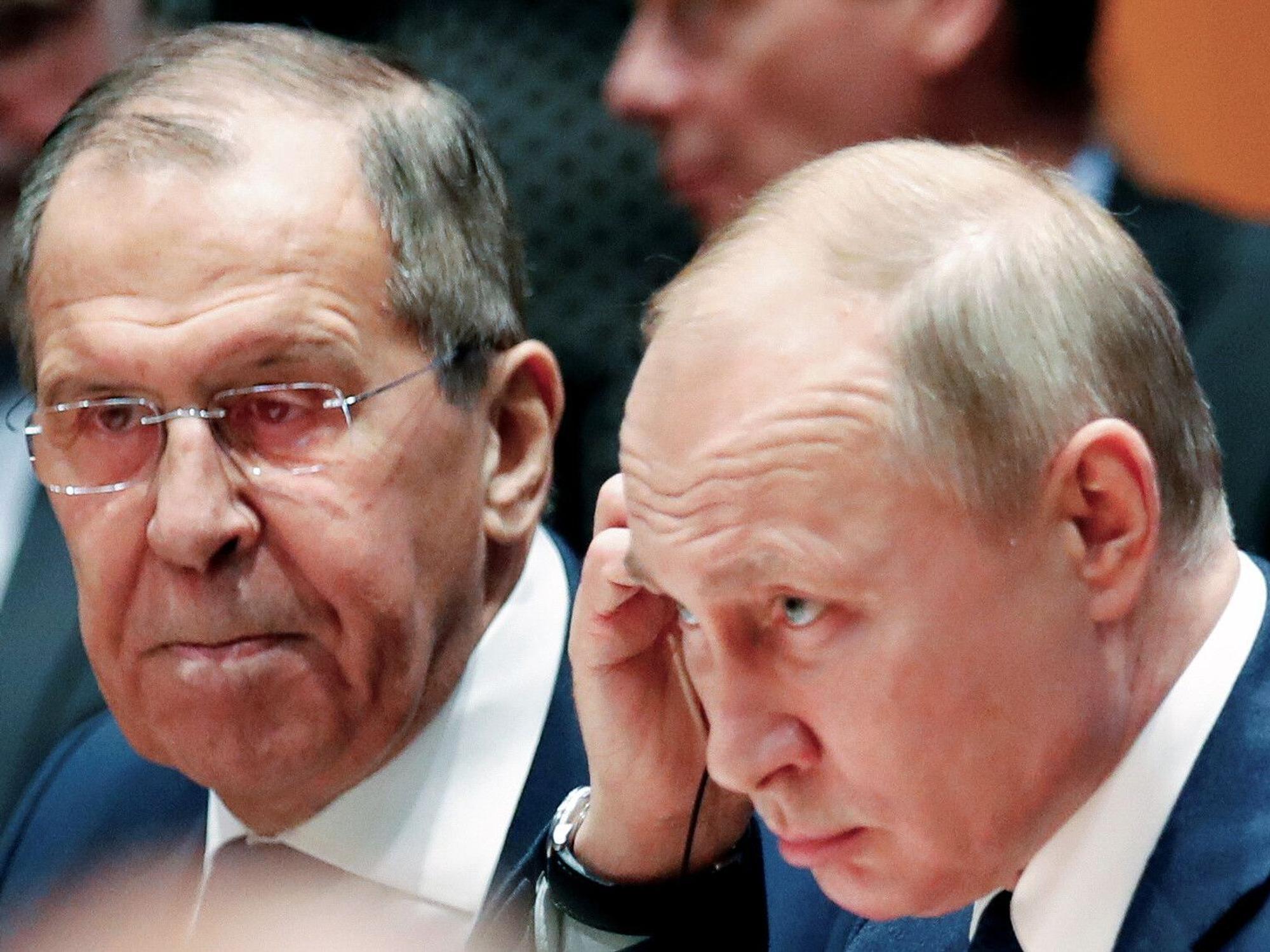Der russische Präsident Wladimir Putin (r) sitzt neben seinem Außenminister Sergej Lawrow