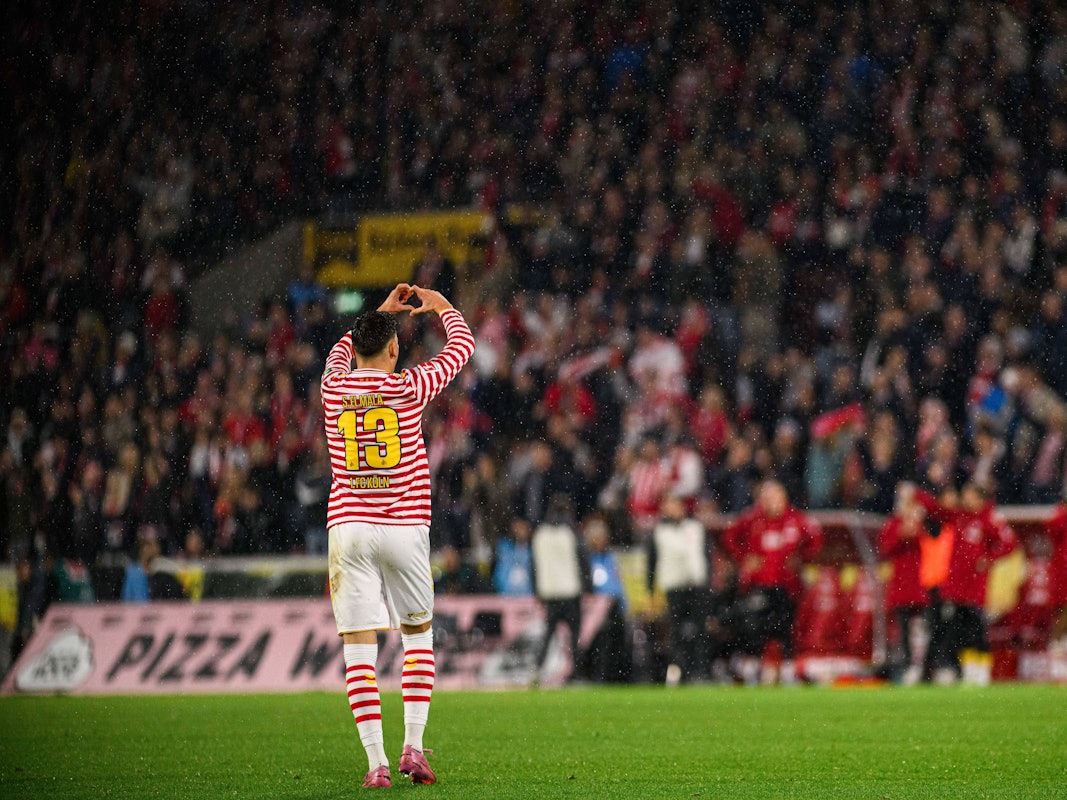 Said El Mala, der von hinten zu sehen ist, formt mit den Händen ein Herz.