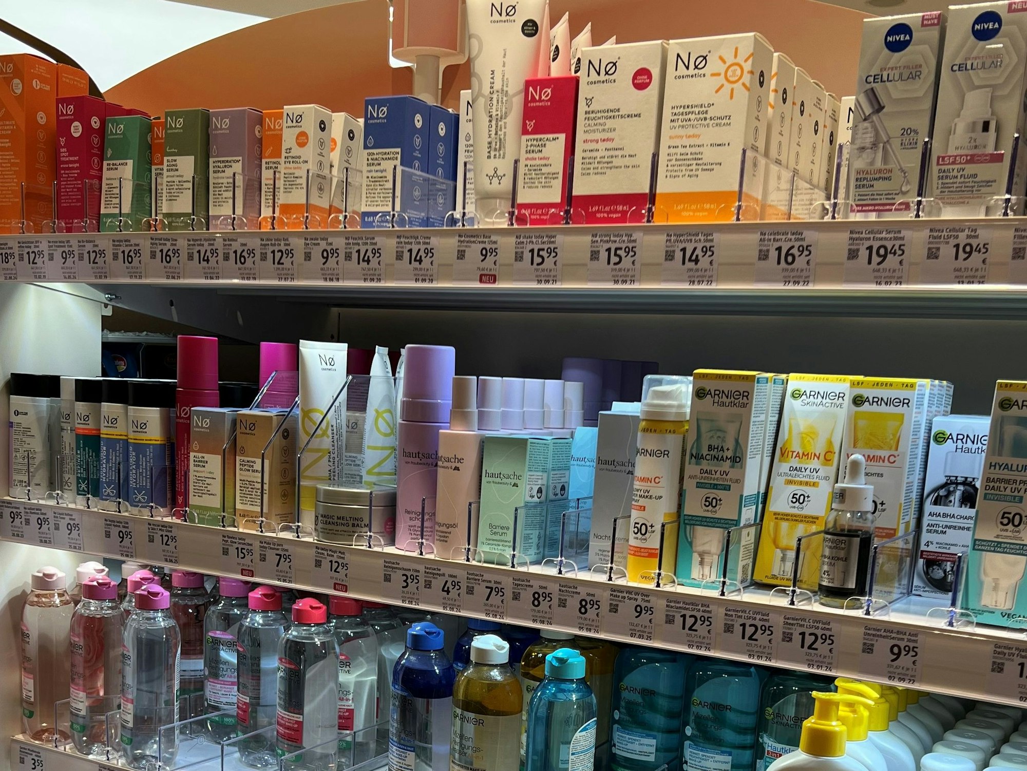 Verschiedene Creme- und Lotionverpackungen stehen in einem Drogerieregal.