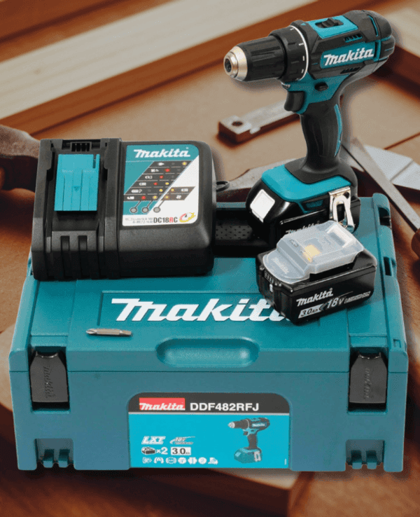 Das Makita Akku-Bohrschrauber-Set – inklusive Bohrer, Ladegerät, Akku und dem robusten MAKPAC-Koffer, präsentiert auf einer Werkbank mit verschiedenen Werkzeugen.