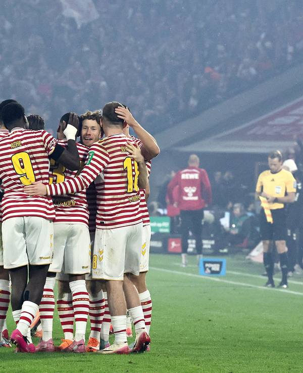 Die FC-Profis jubeln in ihren rot-weiß gestreiften Karnevalstrikot.