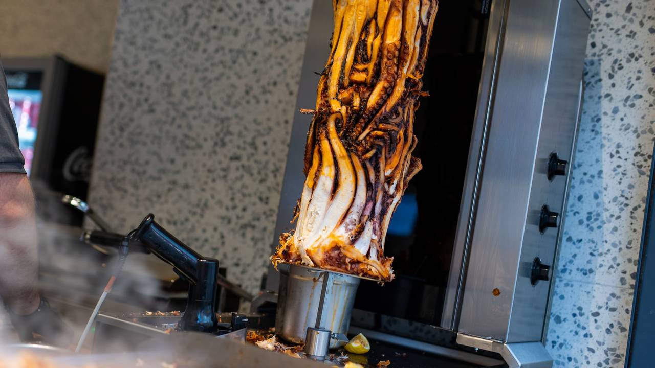 PRODUKTION - 07.11.2025, Baden-Württemberg, Karlsruhe: Ein Calamari-Kebabspiess hängt im Restaurant «Pescobar». Nach der ersten Filiale in London hat ein rumänischer Meeresfrüchte-Anbieter nun seine zweite Filiale mit Calamari-Kebab in Karlsruhe eröffnet. (zu dpa: «Neuer Döner-Hype? Tentakel am Spieß sorgt für Wirbel») Foto: Philipp von Ditfurth/dpa +++ dpa-Bildfunk +++