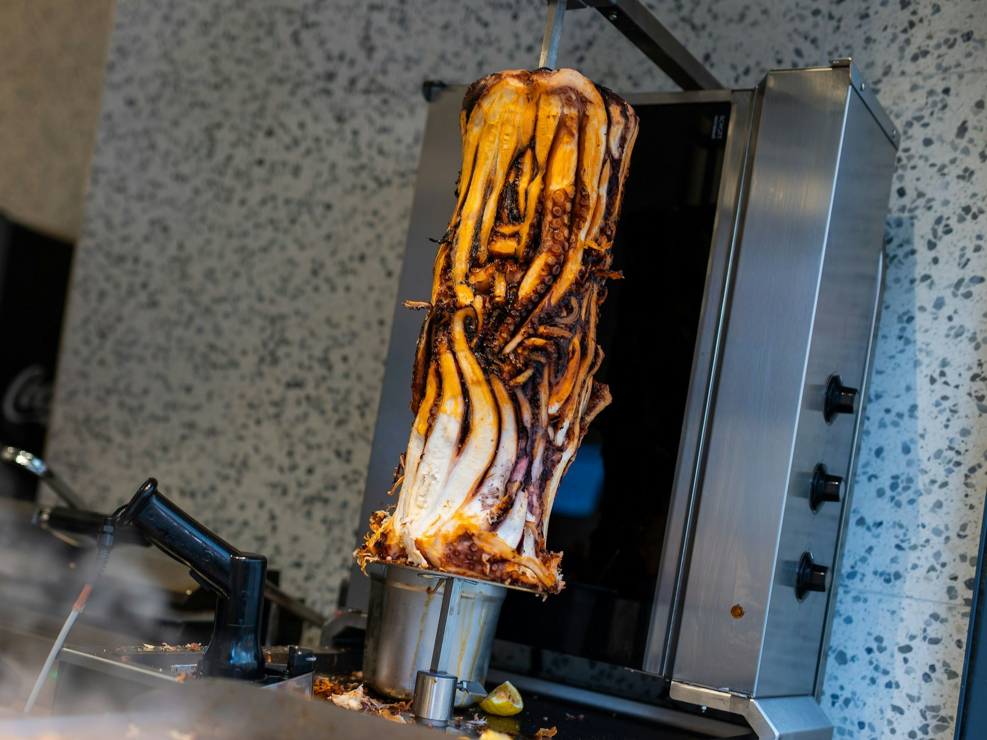 PRODUKTION - 07.11.2025, Baden-Württemberg, Karlsruhe: Ein Calamari-Kebabspiess hängt im Restaurant «Pescobar». Nach der ersten Filiale in London hat ein rumänischer Meeresfrüchte-Anbieter nun seine zweite Filiale mit Calamari-Kebab in Karlsruhe eröffnet. (zu dpa: «Neuer Döner-Hype? Tentakel am Spieß sorgt für Wirbel») Foto: Philipp von Ditfurth/dpa +++ dpa-Bildfunk +++