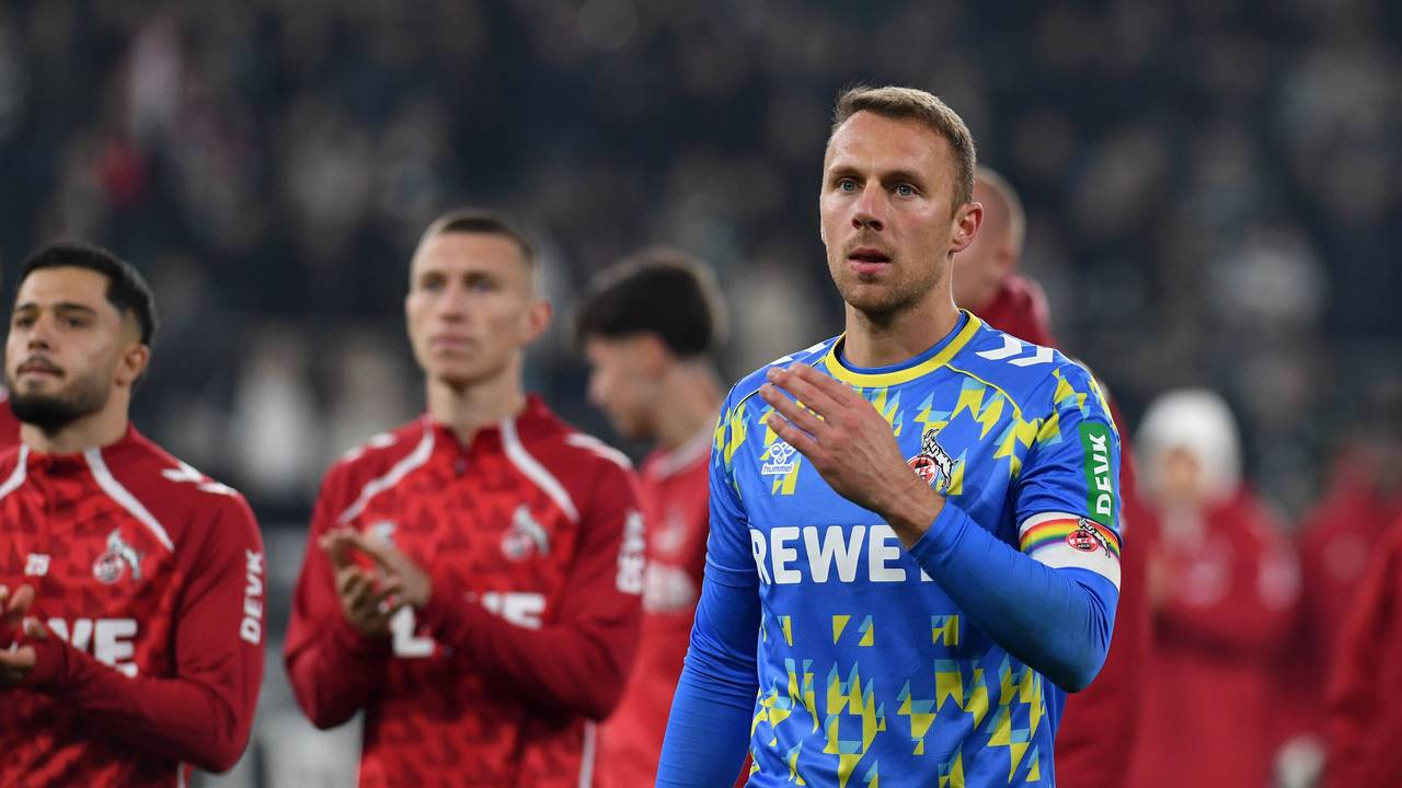 Marvin Schwäbe und weitere Spieler des 1. FC Köln im Hintergrund bedanken sich bei den Fans im Stadion.
