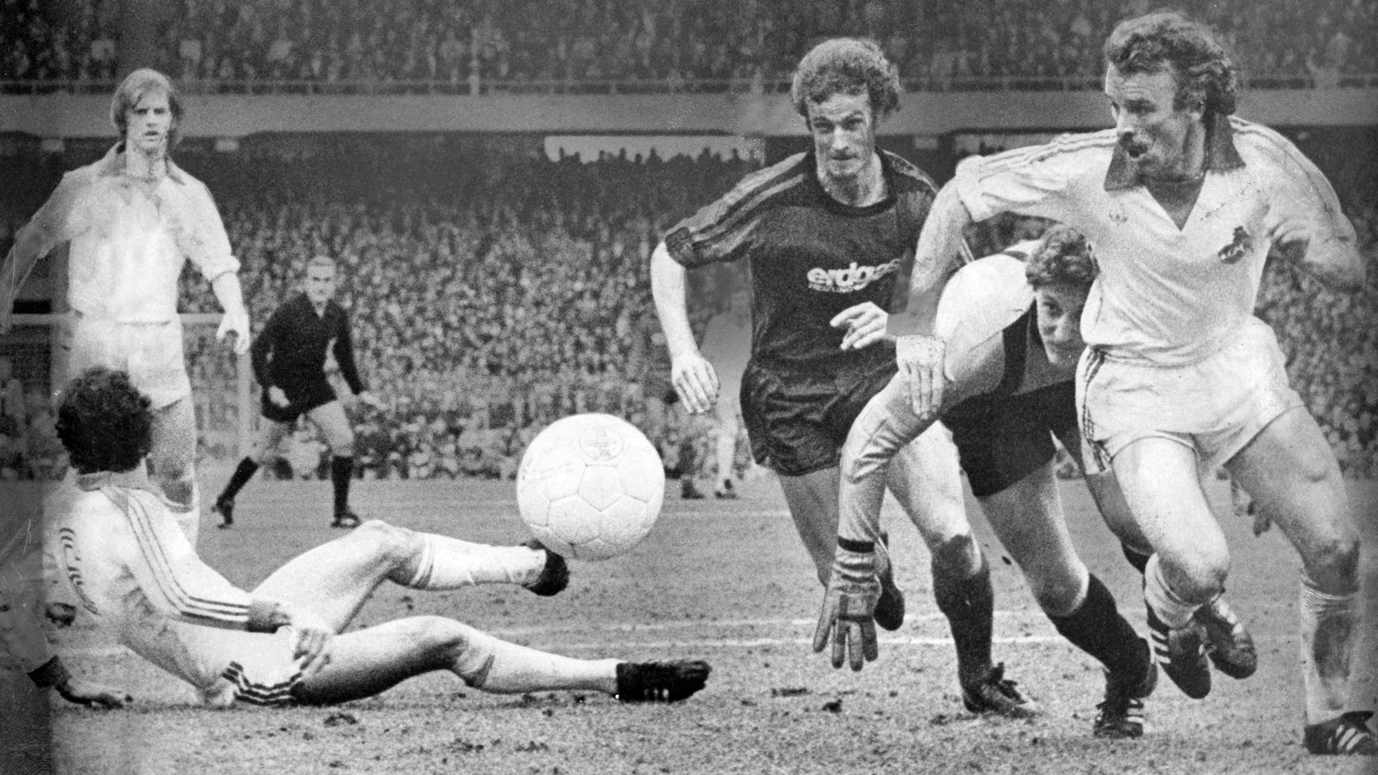 Fußballer wollen einen Ball erobern.