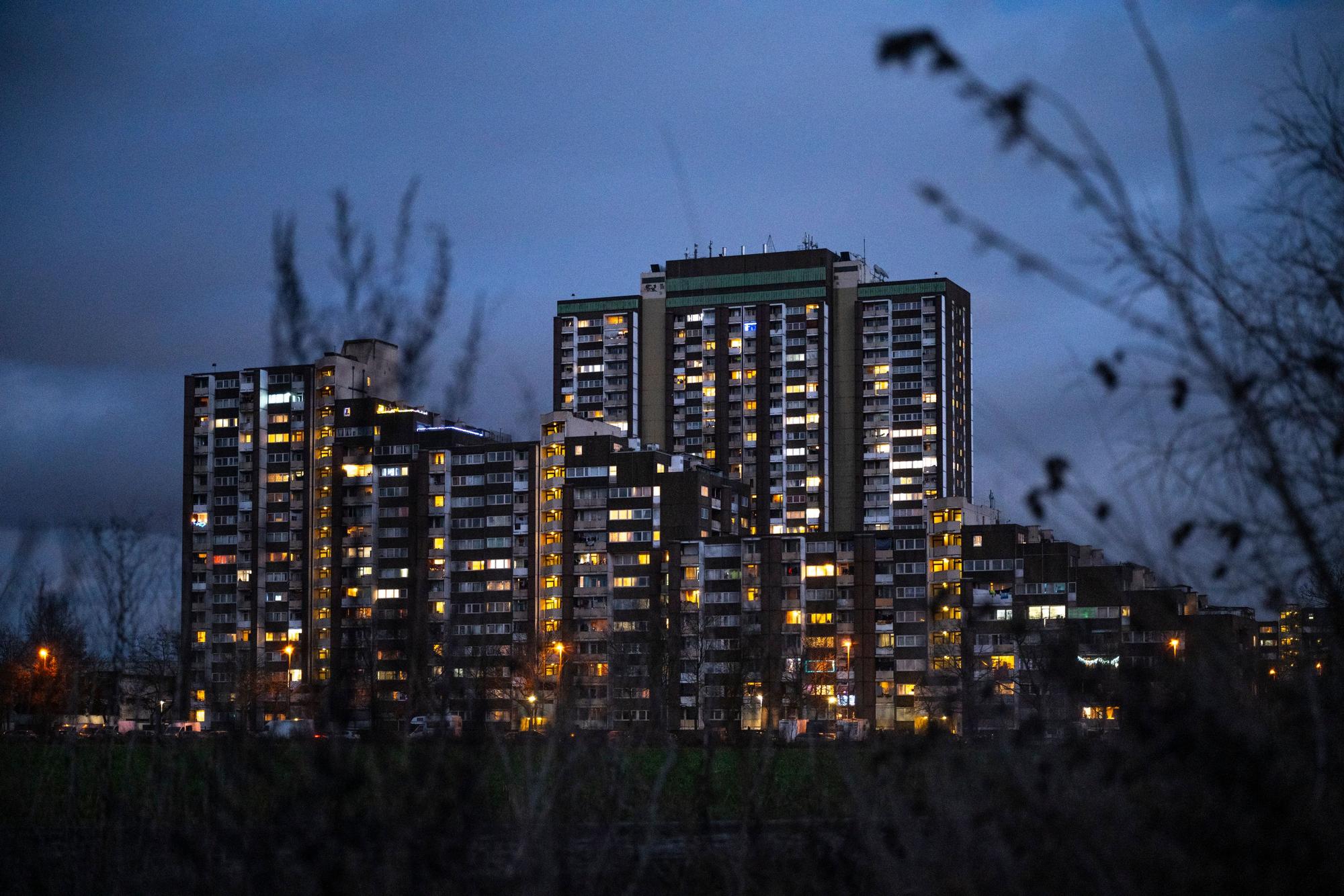 Die Hochhäuser am Kölnberg in Meschenich sind in der Abenddämmerung weihnachtlich beleuchtet.