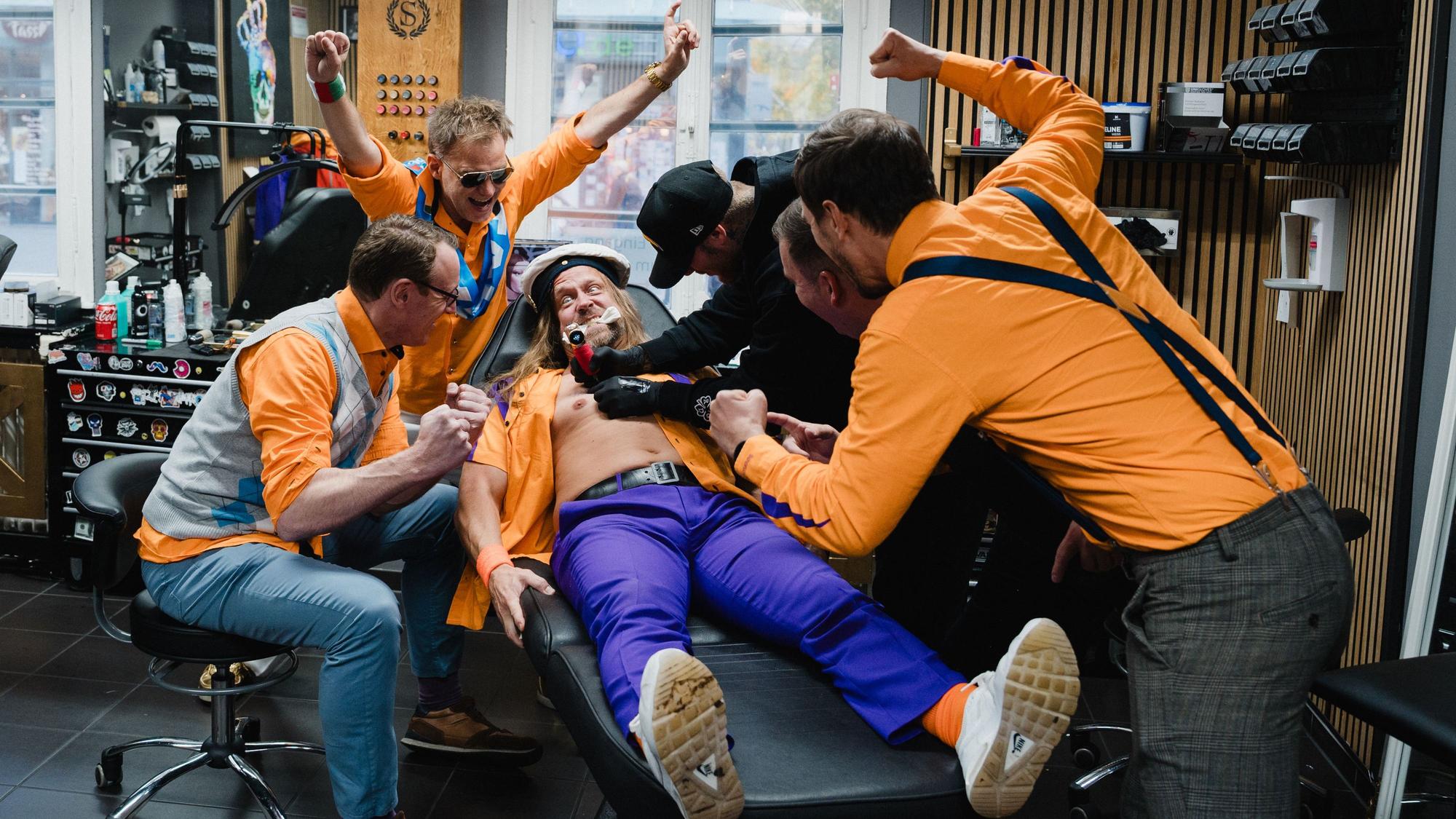 Szene aus dem Video der Band Tacheles. Sänger Rainer Schuster bekommt ein Tattoo.