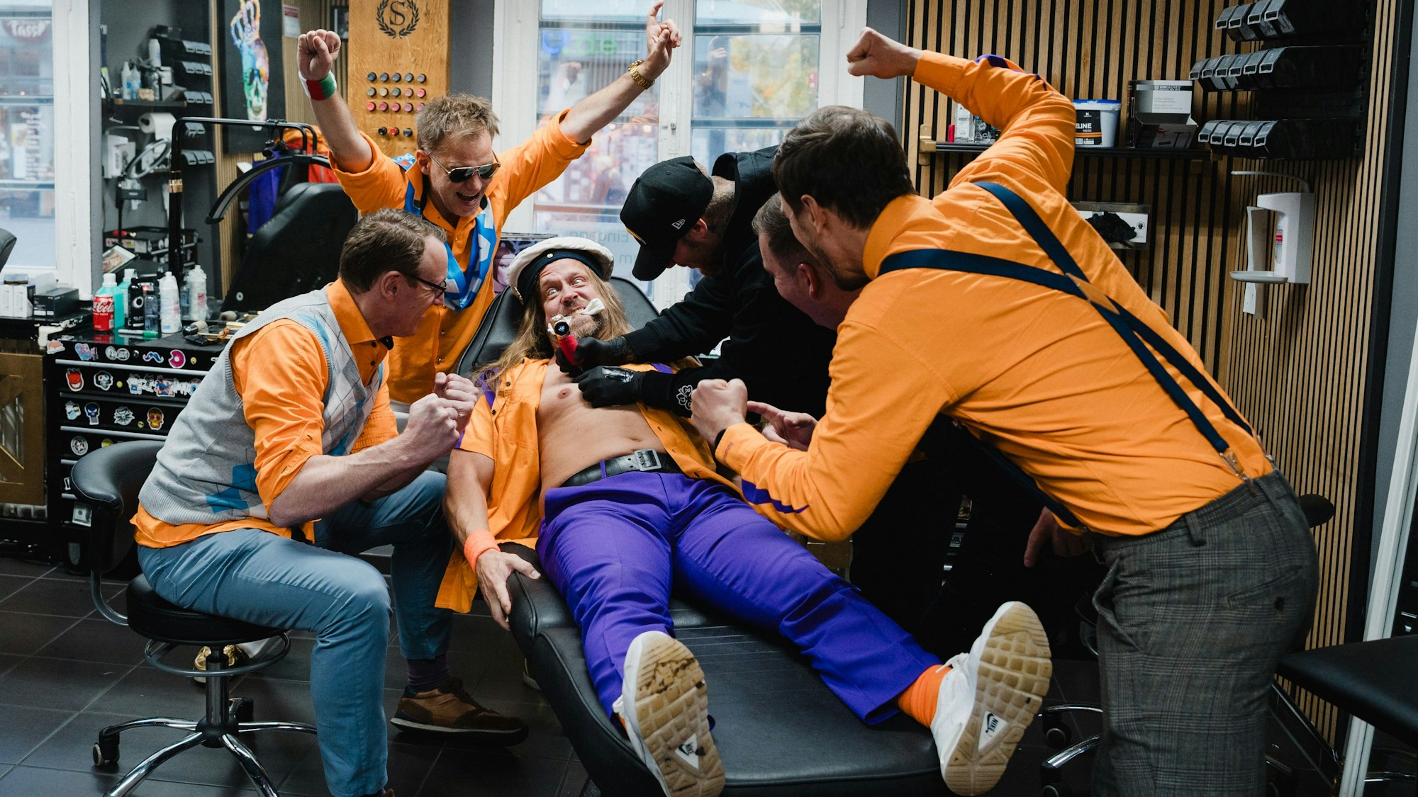 Szene aus dem Video der Band Tacheles. Sänger Rainer Schuster bekommt ein Tattoo.