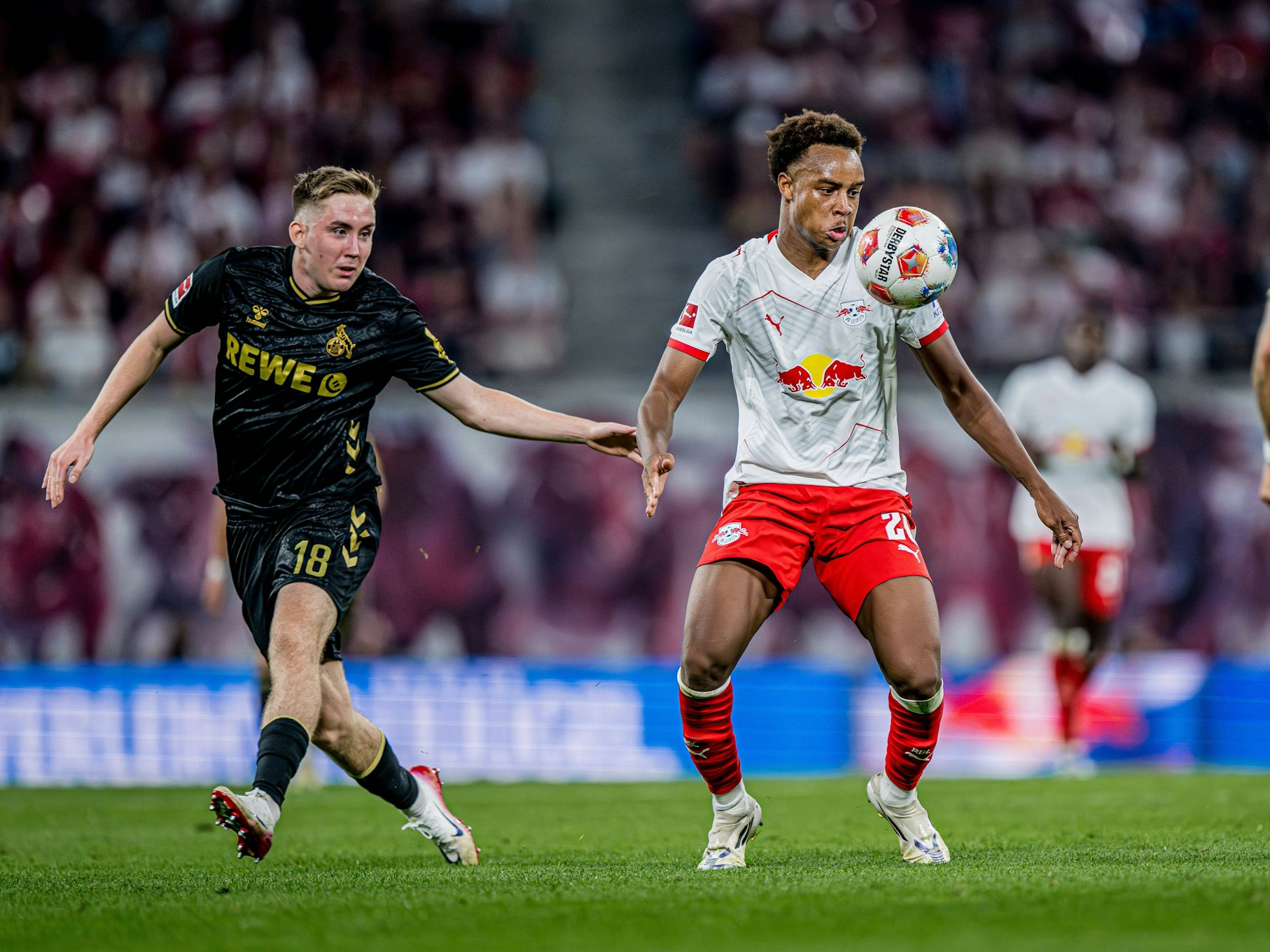 Assan Ouédraogo blickt auf den Ball vor sich in der Luft. Neben ihm steht Isak Johannesson.