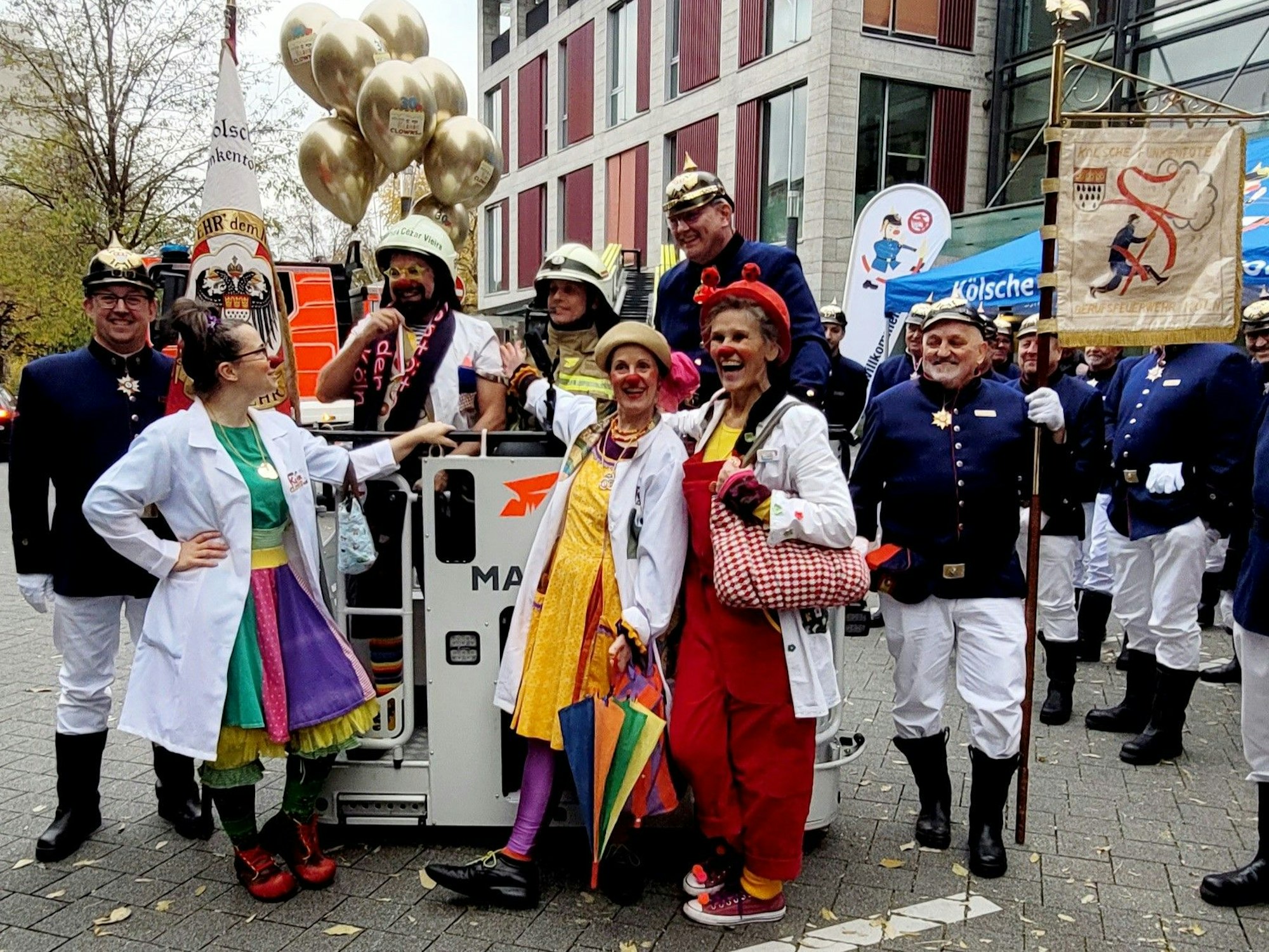 Die Kölner Klinik-Clowns stehen bei der Ehrung an der Drehleiter.