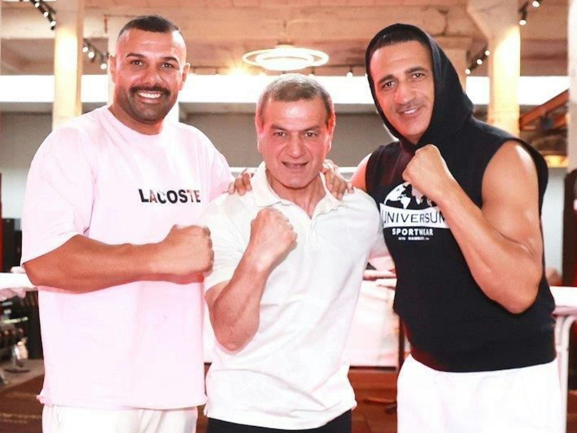 Drei Männer stehen nebeneinander und ballen jeweils eine Faust.