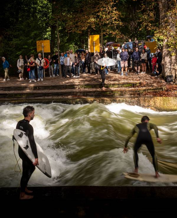 Surfer reiten auf einer Welle in einem Bach.