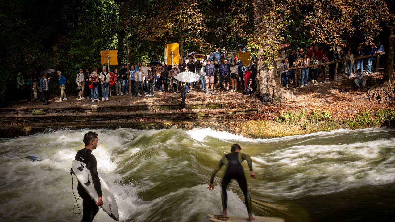 Surfer reiten auf einer Welle in einem Bach.