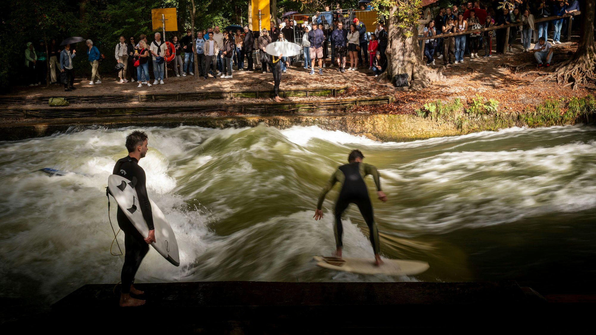 Surfer reiten auf einer Welle in einem Bach.