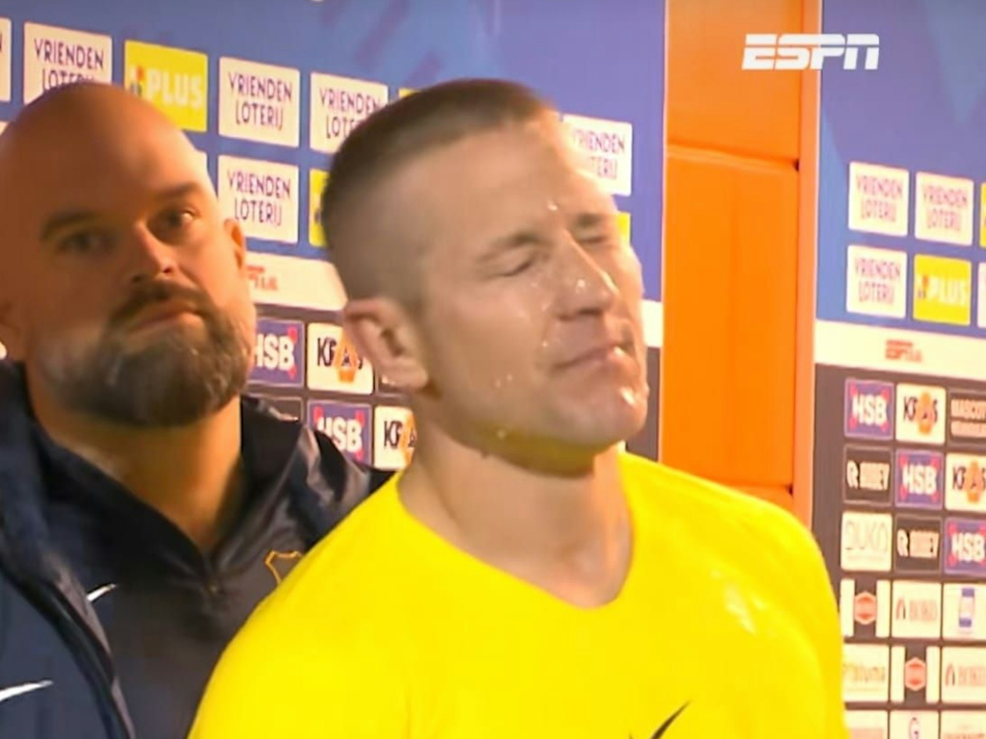 Lewis Holtby steht am Eingang des Spielertunnels und bekommt eine Flüssigkeit von oben ins Gesicht.