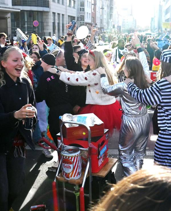 Verkleidete Menschen tanzen auf offener Straße.