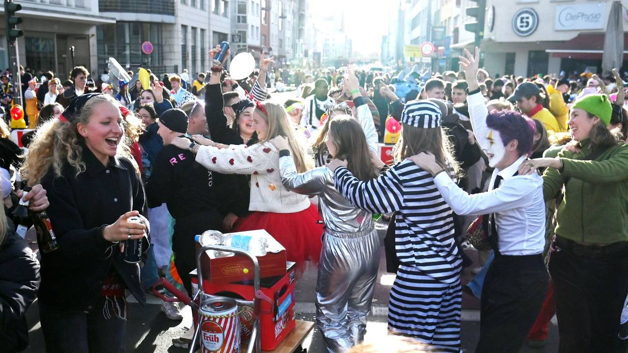 Verkleidete Menschen tanzen auf offener Straße.