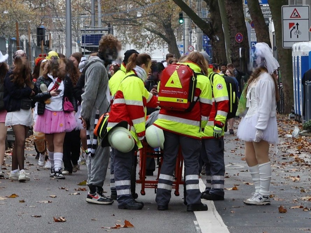 Rettungskräfte kümmern sich um eine Person, die auf einer Rolltrage liegt.