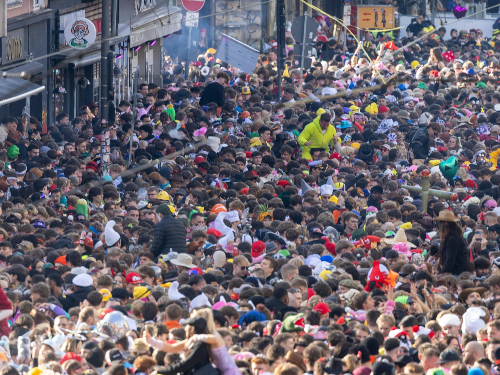 Auf einer Straßen drängen sich kostümierte Menschen dicht an dicht.