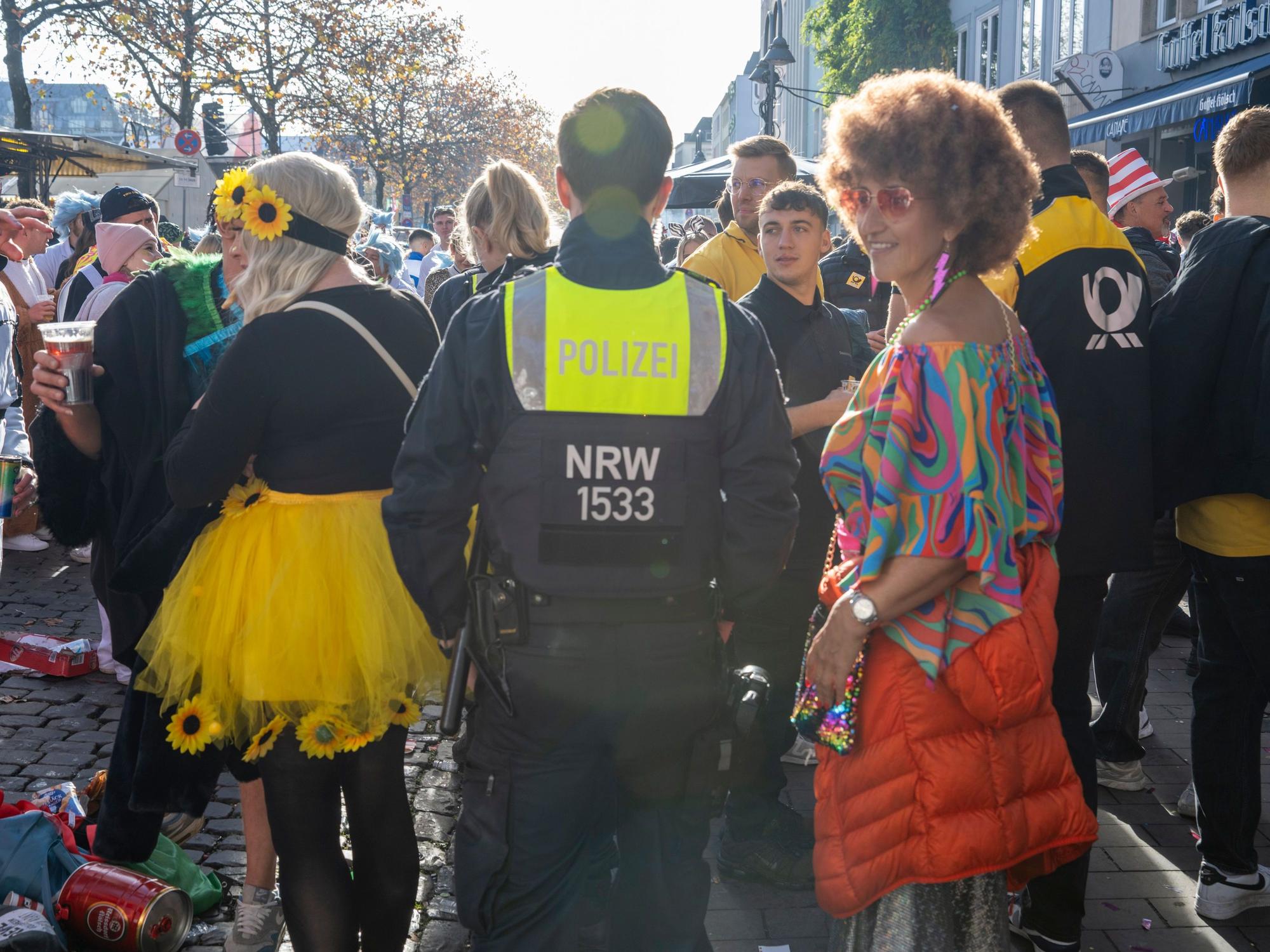 Ein Polizist bahnt sich den Weg durch verkleidete Menschen.