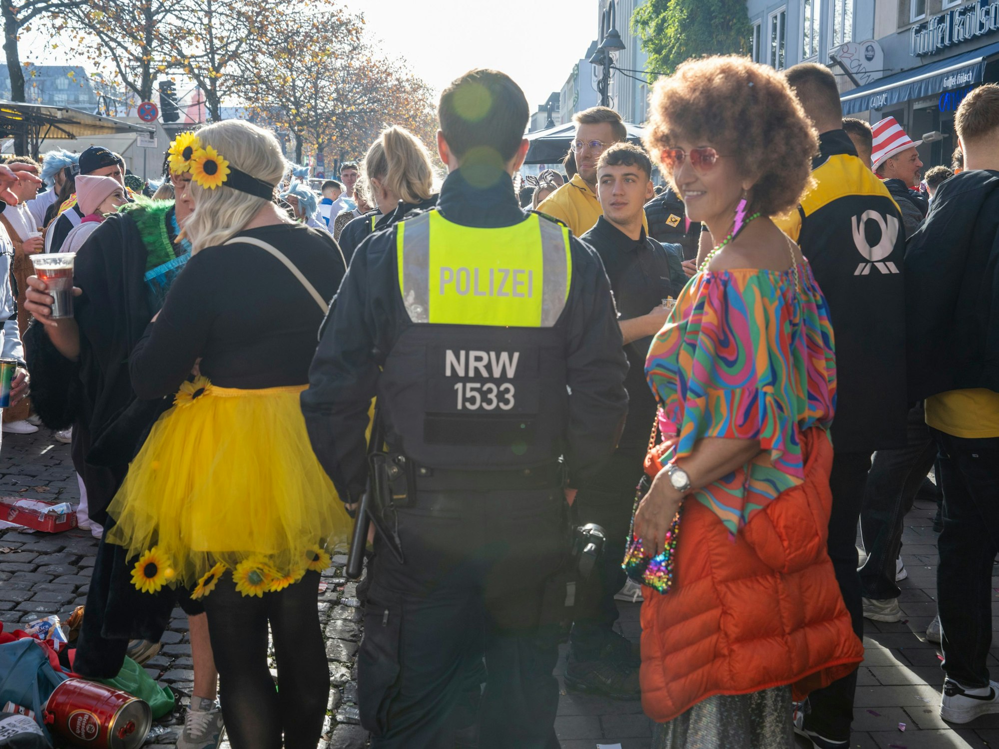 Ein Polizist bahnt sich den Weg durch verkleidete Menschen.