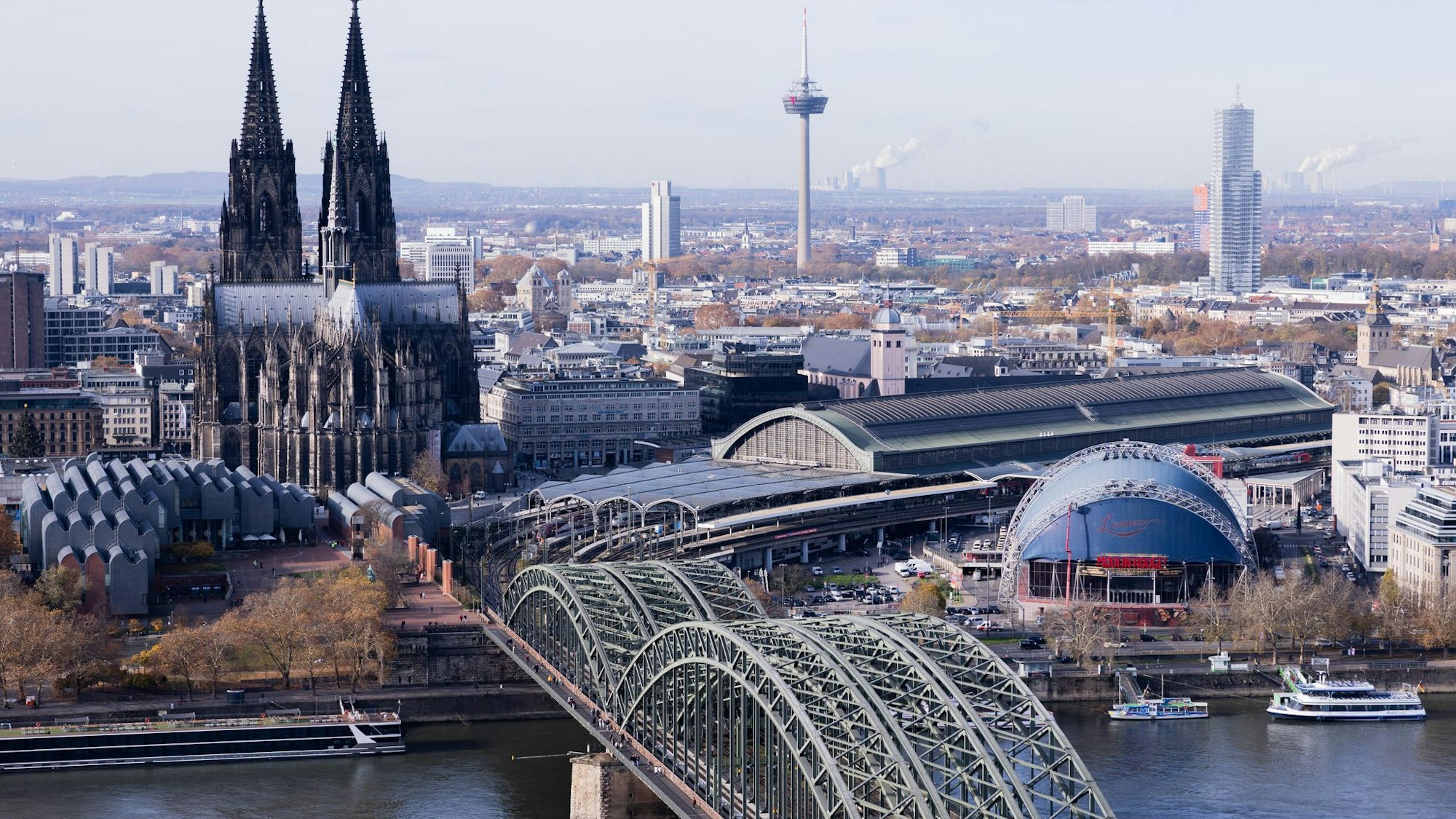 Eine Brücke führt zum Kölner Hauptbahnhof, dahinter der Kölner Dom.