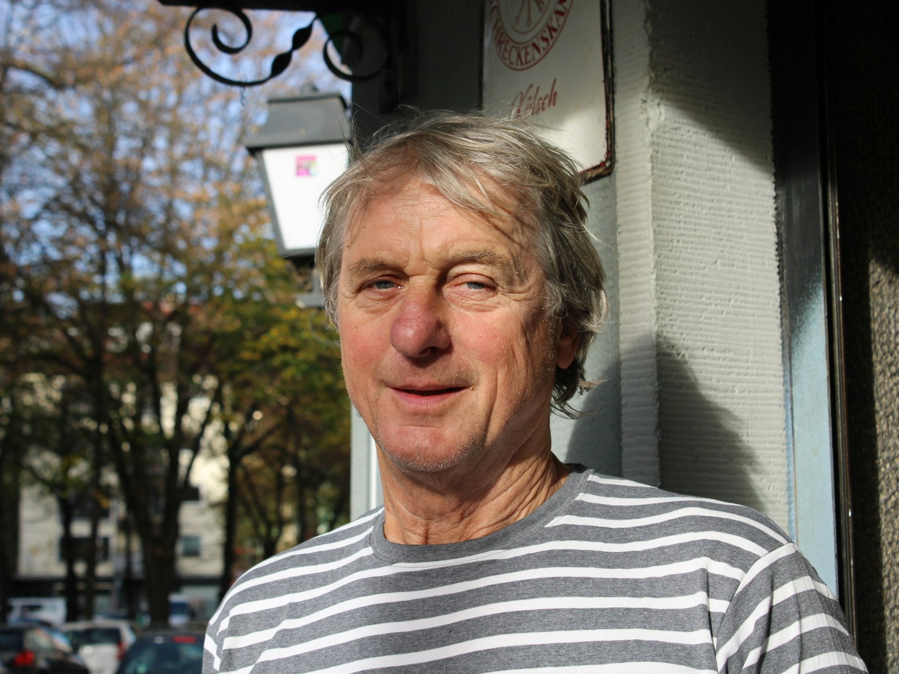 Ein Mann steht vor einer Kneipe.