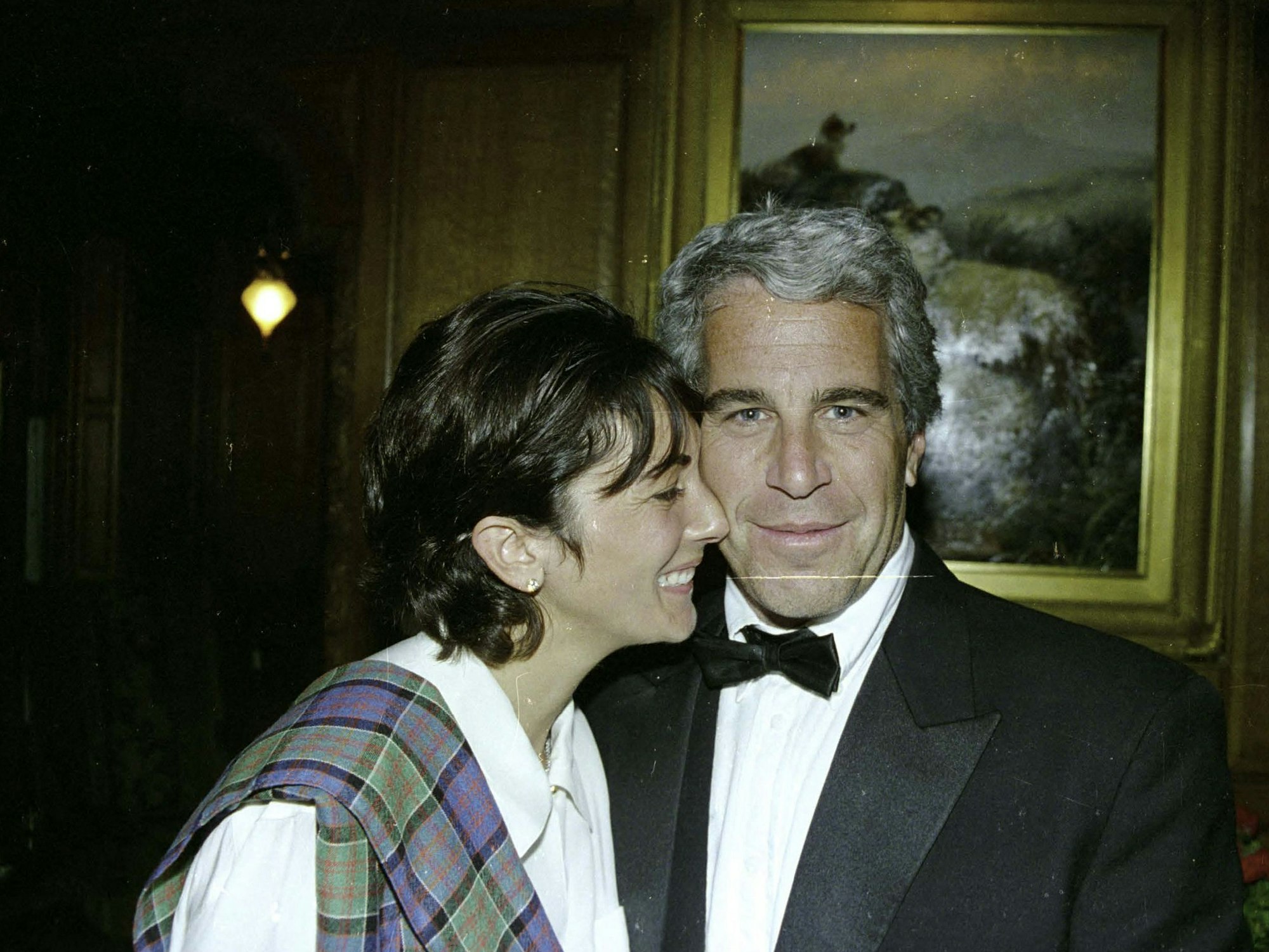 Eine Frau drückt ihr Gesicht seitlich an das Gesicht eines Mannes.