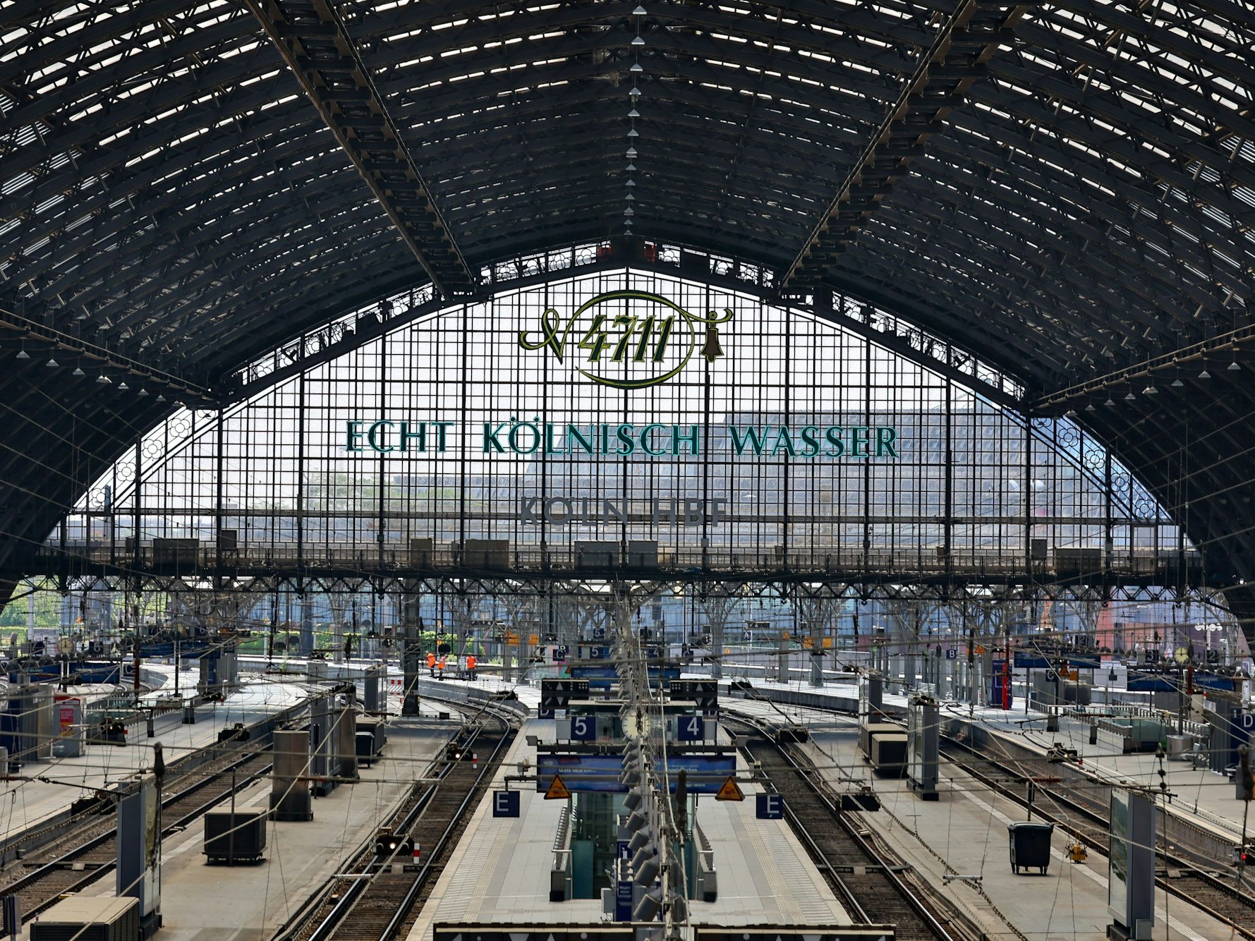 Die Gleise des Kölner Hauptbahnhofs sind von einer Kuppel überdacht, an deren Kopfende der Schriftzug „4711 Echt Kölnisch Wasser“ steht.