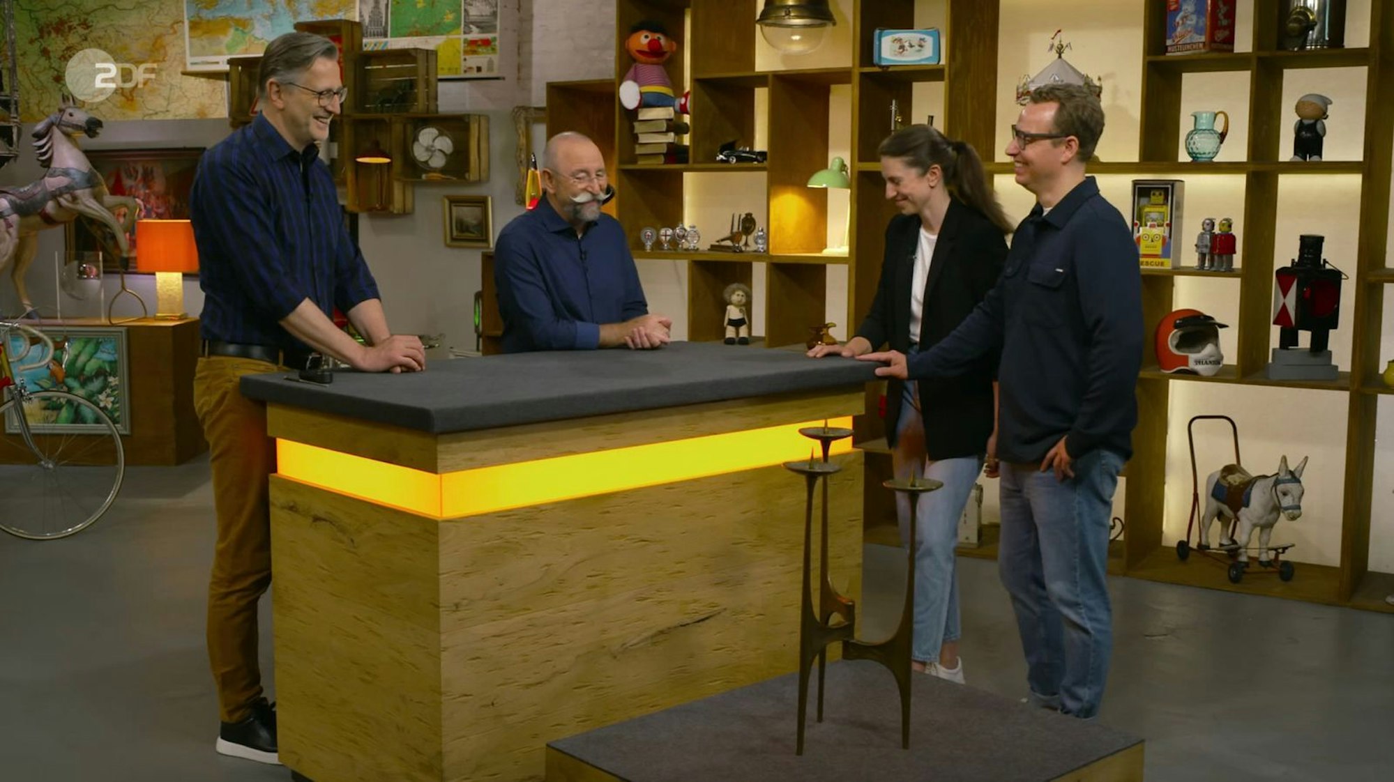 Ein Kerzenständer sorgte bei „Bares für Rares“ für gemischte Reaktionen, von links: Experte Detlev Kümmel, Moderator Horst Lichter, Kandidaten Marisa und Christopher. (Bild: ZDF)