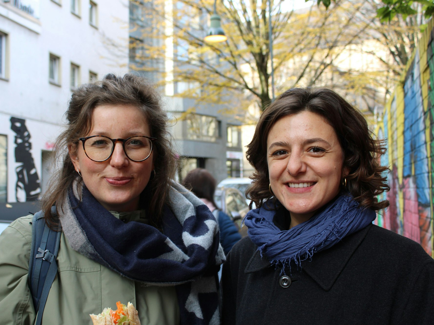 Zwei Frauen stehen an einer Straße.