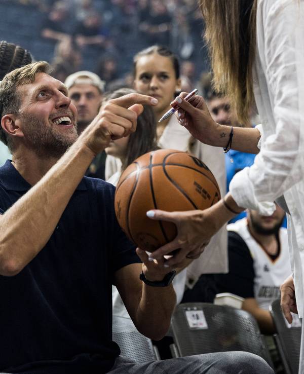 Dirk Nowitzki, ehemaliger deutscher Basketballer, gibt lachend Autogramme.