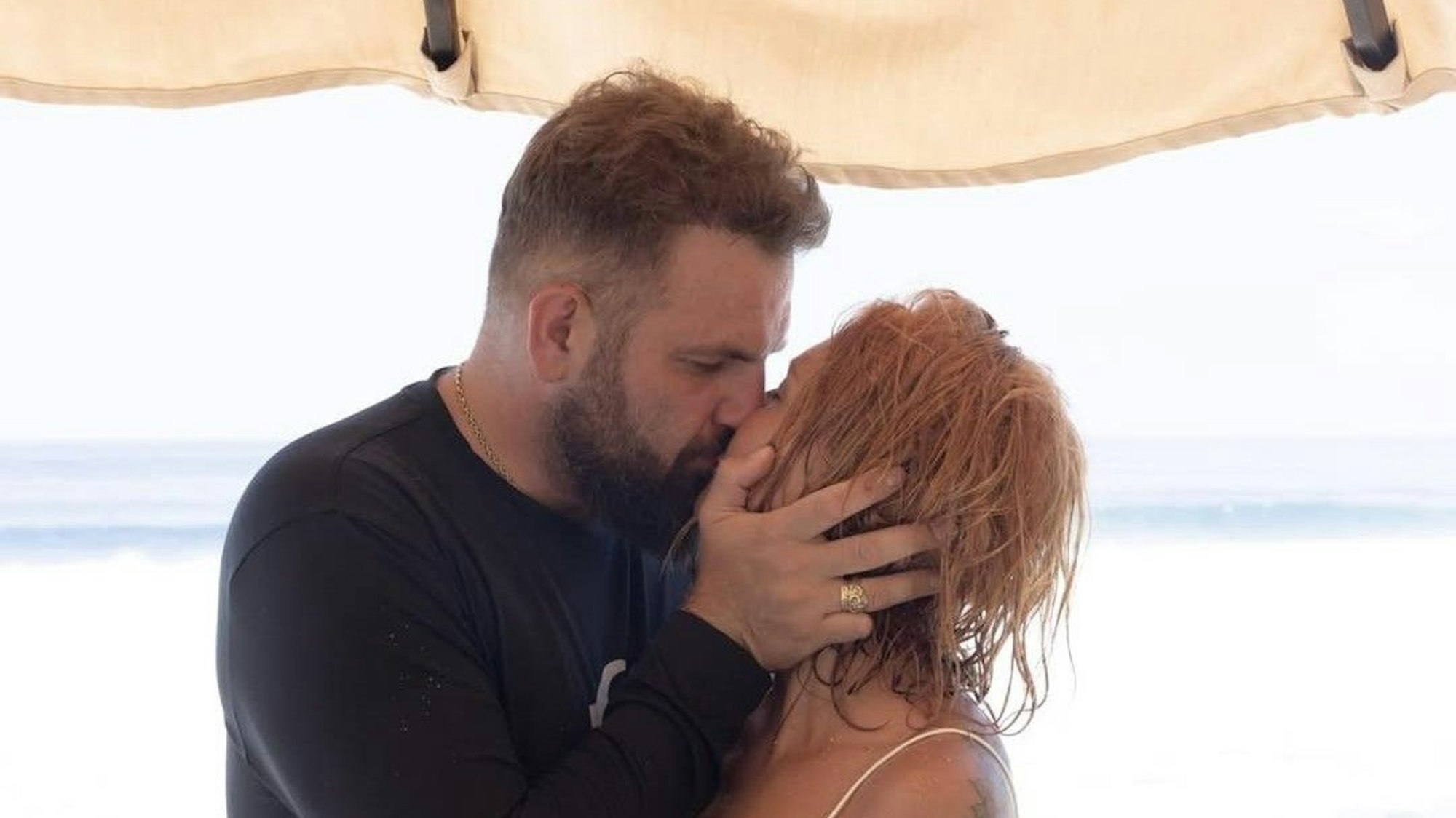 Roman Novak und seine Frau küssen sich.