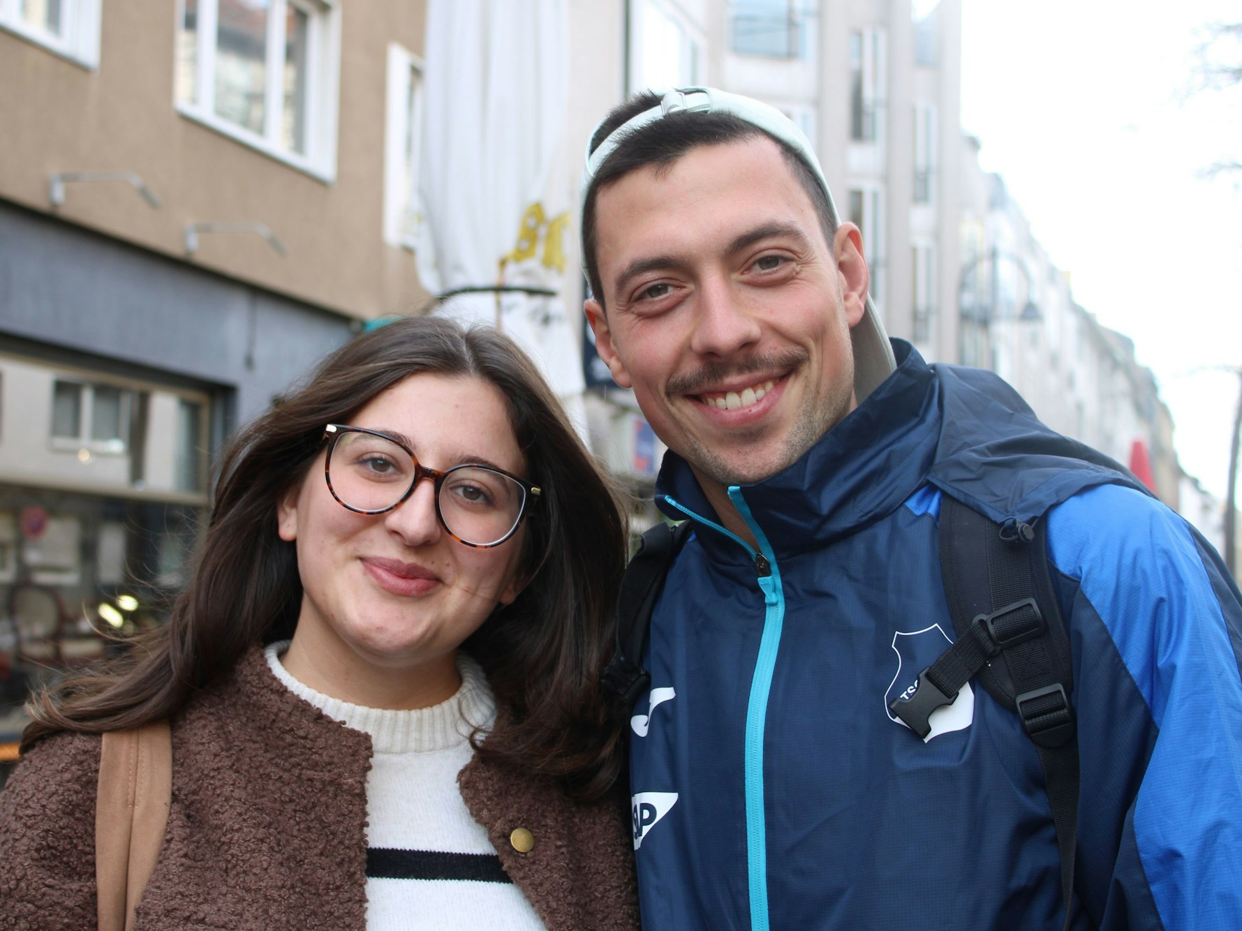Ein Pärchen steht Arm in Arm an einer Straße.