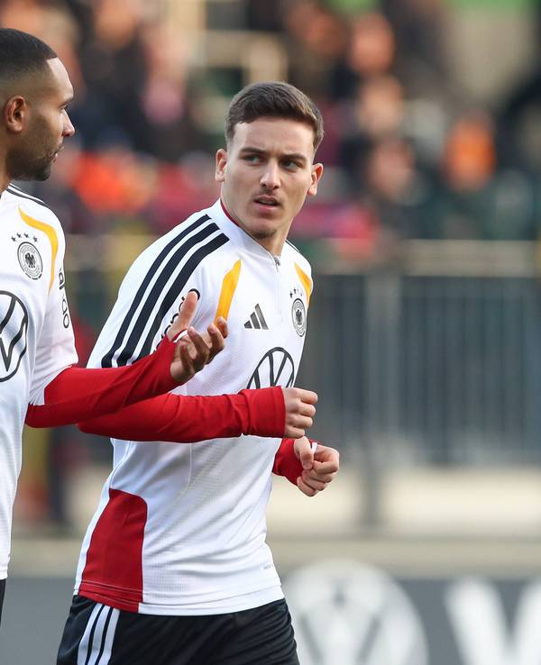 Jonathan Tah und Said El Mala unterhalten sich, während sie im Training laufen.