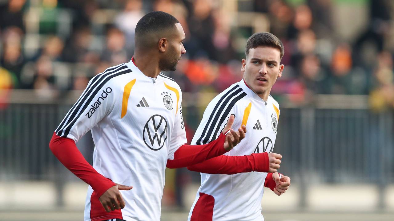 Jonathan Tah und Said El Mala unterhalten sich, während sie im Training laufen.