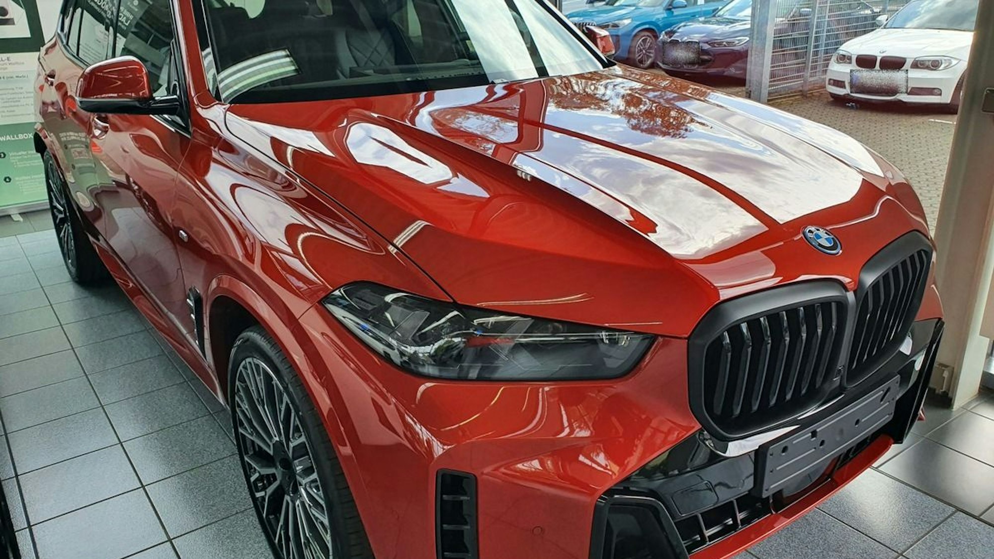 Der auffällige rot-orangefarbene BMW X5.