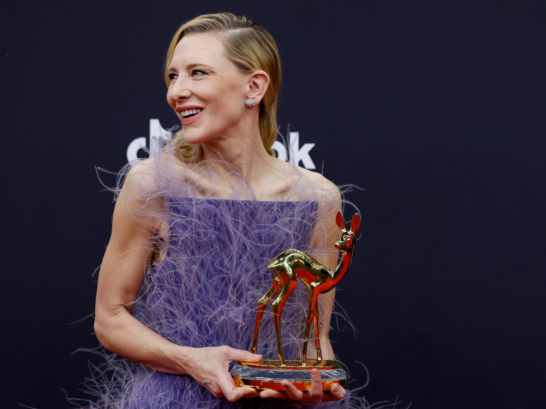 Eine Frau hält eine Rehkitz-Statue in der Hand.