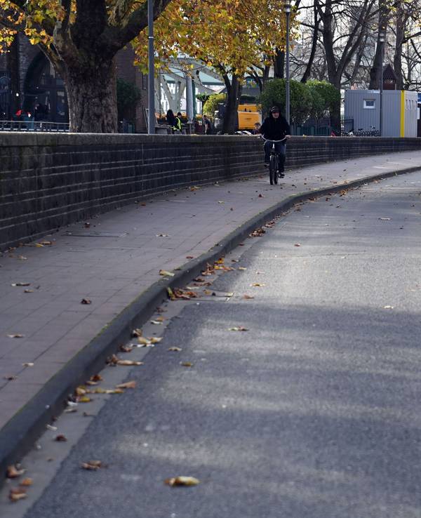 Arbeiter bauen einen Radweg auf einer Straße ab.