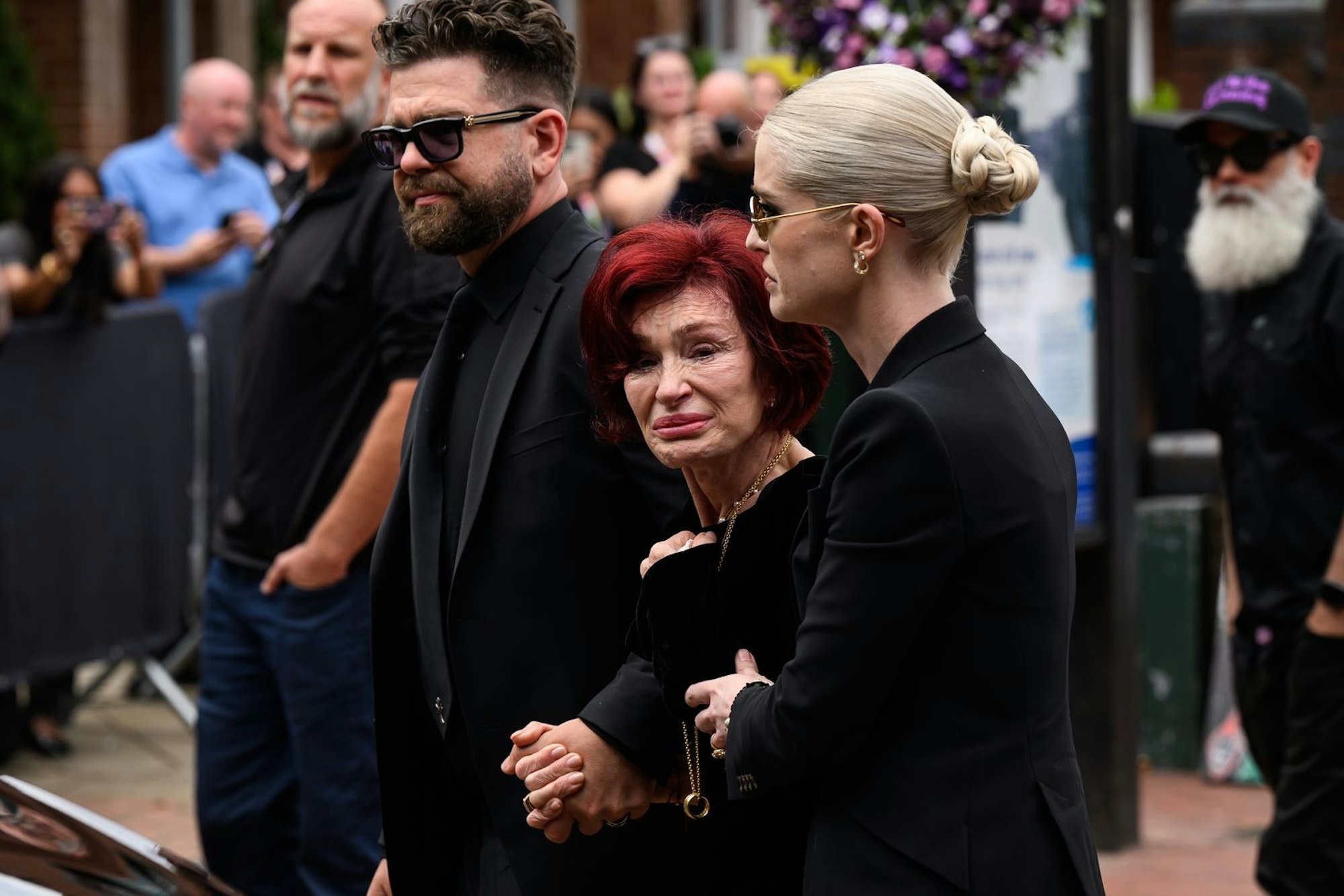 Trauer um Ozzy: Jack Osbourne, Sharon Osbourne (Mitte) und Kelly Osbourne weinen bei der Beerdigung der Rocklegende Ende Juli in seiner Heimatstadt Birmingham. (Bild: Leon Neal/Getty Images)