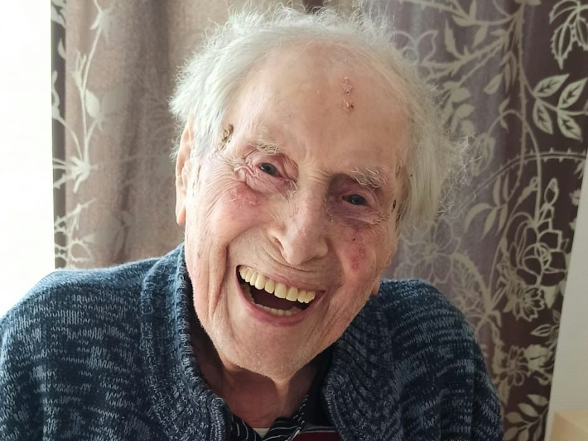 Ludwig Sebus lacht in seinem Wohnzimmer in Ossendorf.