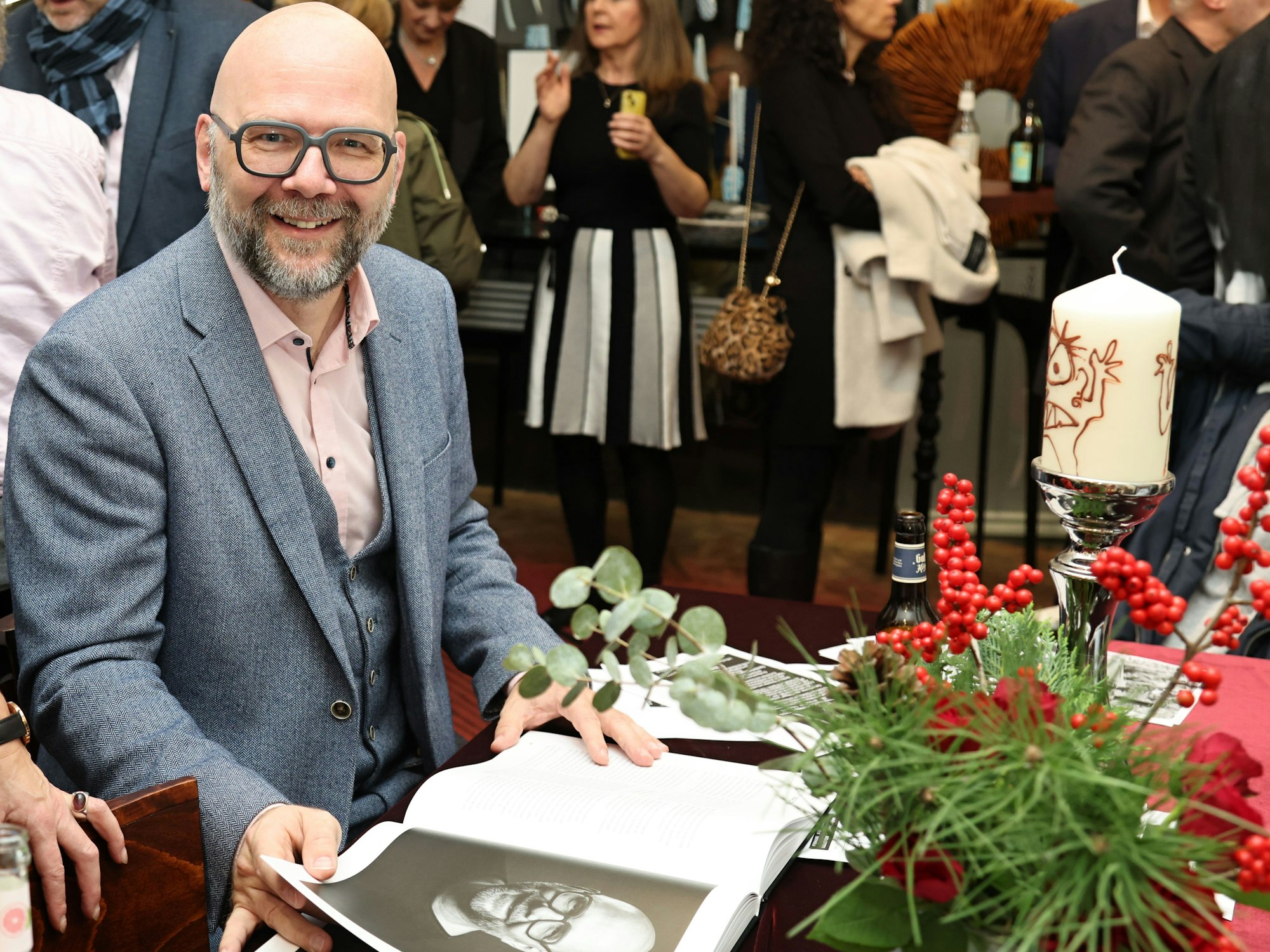 Philipp Walter schaut sich sein Portrait im Buch an.