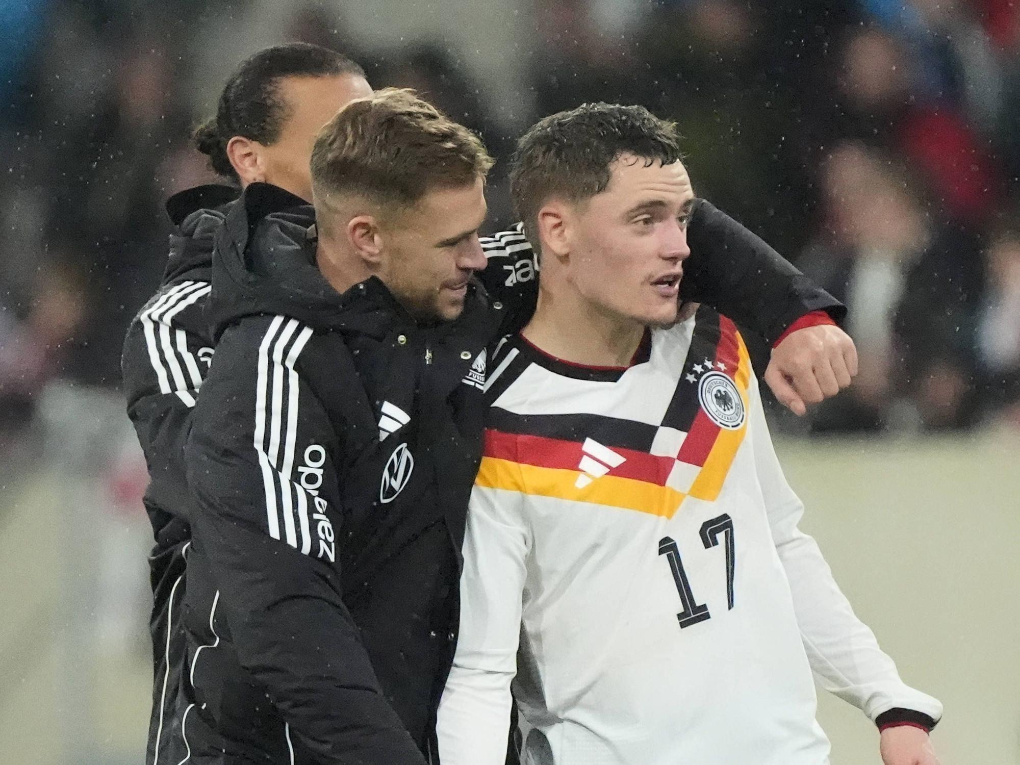 Joshua Kimmich umarmt Florian Wirtz nach dem Spiel.