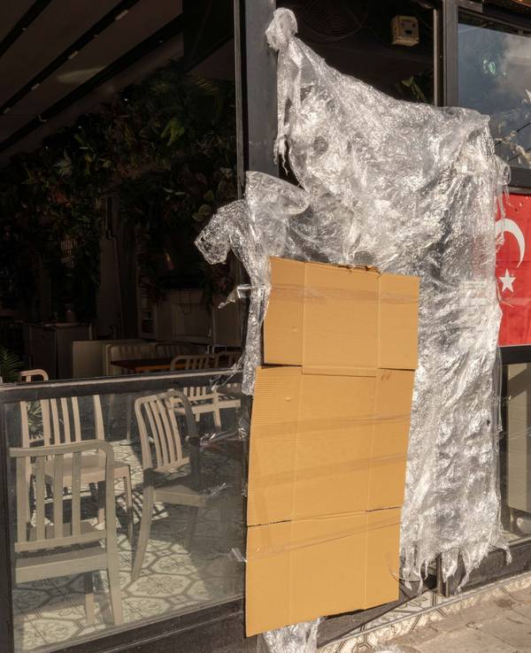 An einem türkischen Stand für Streetfood, der von den türkischen Behörden geschlossen wurde, hängen eine Pappe und eine Plastikplane neben einer türkischen Fahne.