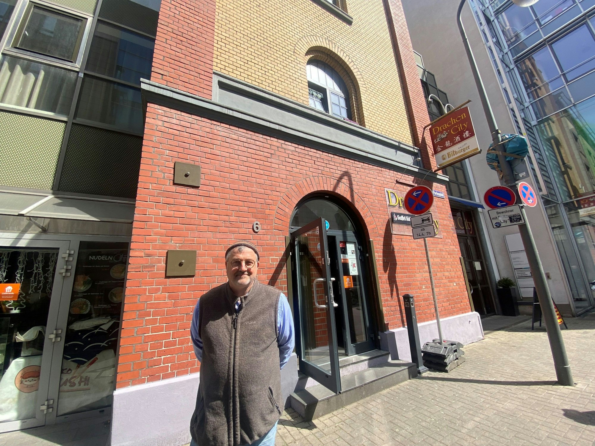 Mann steht vor Gebäude