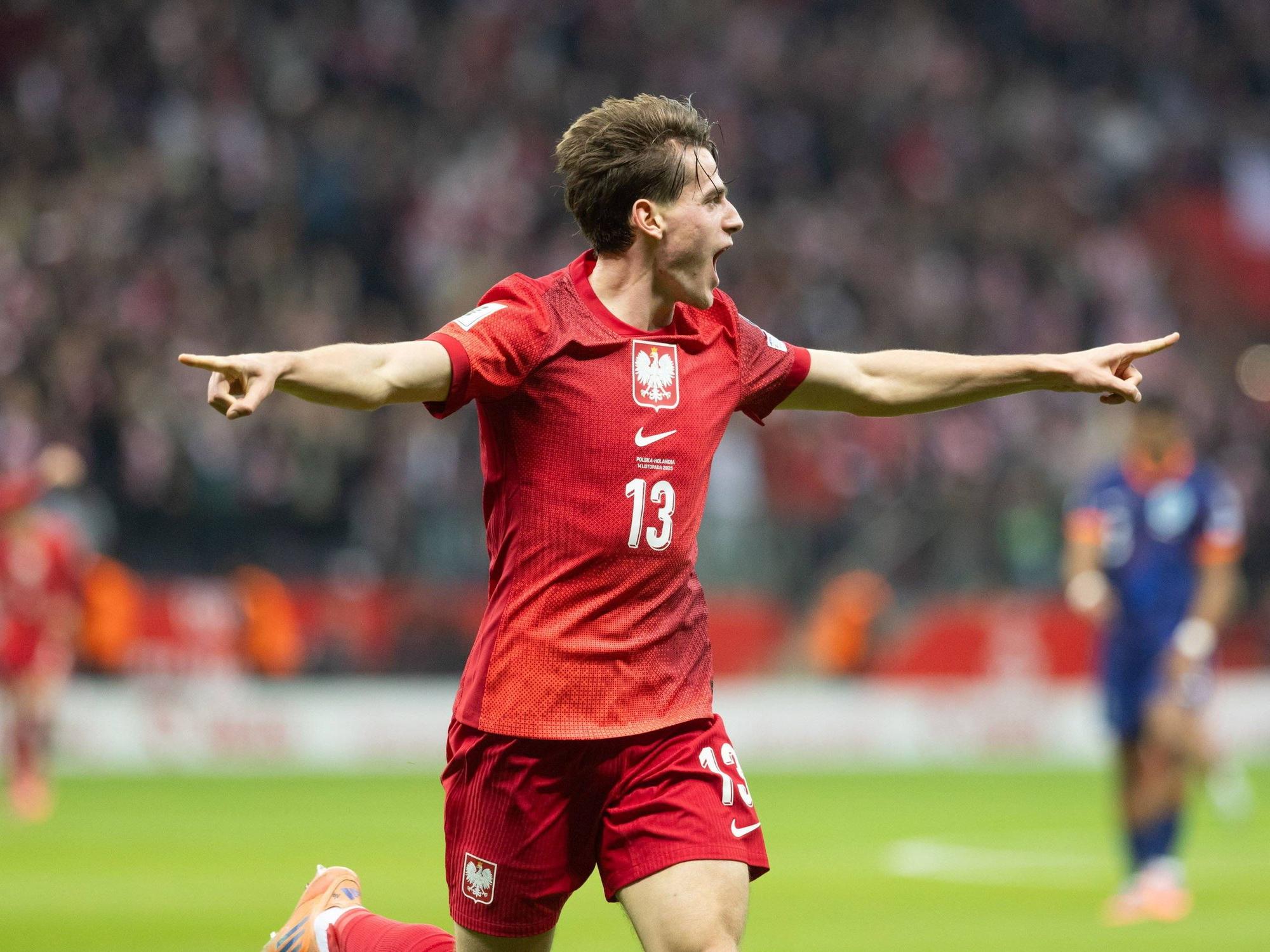 Jakub Kaminski bejubelt seinen Treffer gegen die Niederlande und breitet seine Arme aus.